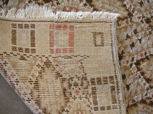 An antique carpet with dry rot after repair (showing the back side).