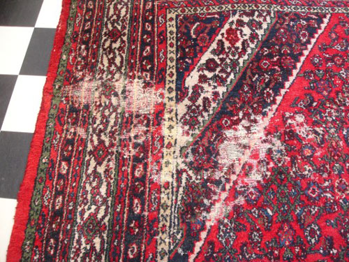 An example of an oriental rug with moth damage.