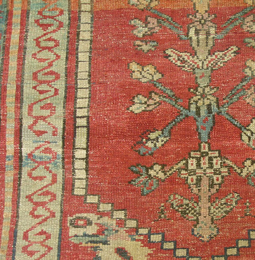 An antique Turkish rug with large worn areas after repair.