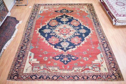 An antique Persian Serapi with large worm areas after repair.