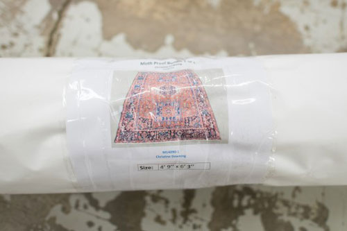 An oriental rug wrapped in an moth proof bundle and ready for safe storage.