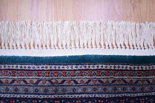 An oriental rug with damaged fringe after repair.
